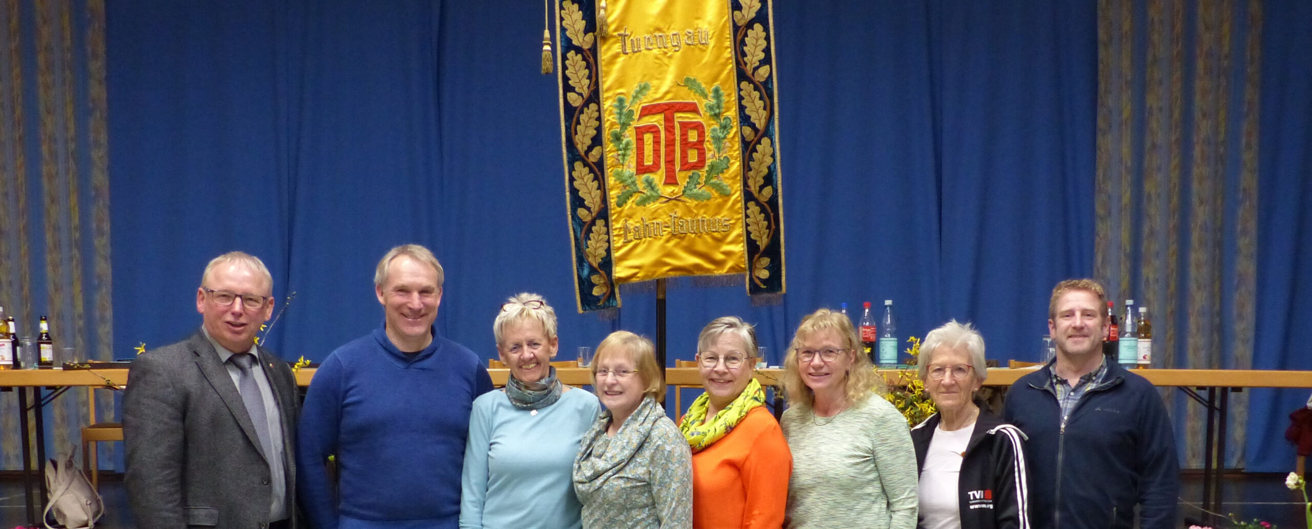 Vorstand des Turngau Rhein-Lahn. Das Bild zeigt acht Personen vor dem Banner des Turngaus.